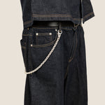 ICED London denim jeans with a silver chain attached to the belt loop, close-up side view.