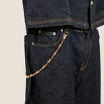 ICED London denim jeans with a rose-gold chain hanging from the belt loop; close-up detail.