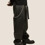 ICED London: black leather pants with silver chain accessory, paired with chunky-sole black boots.