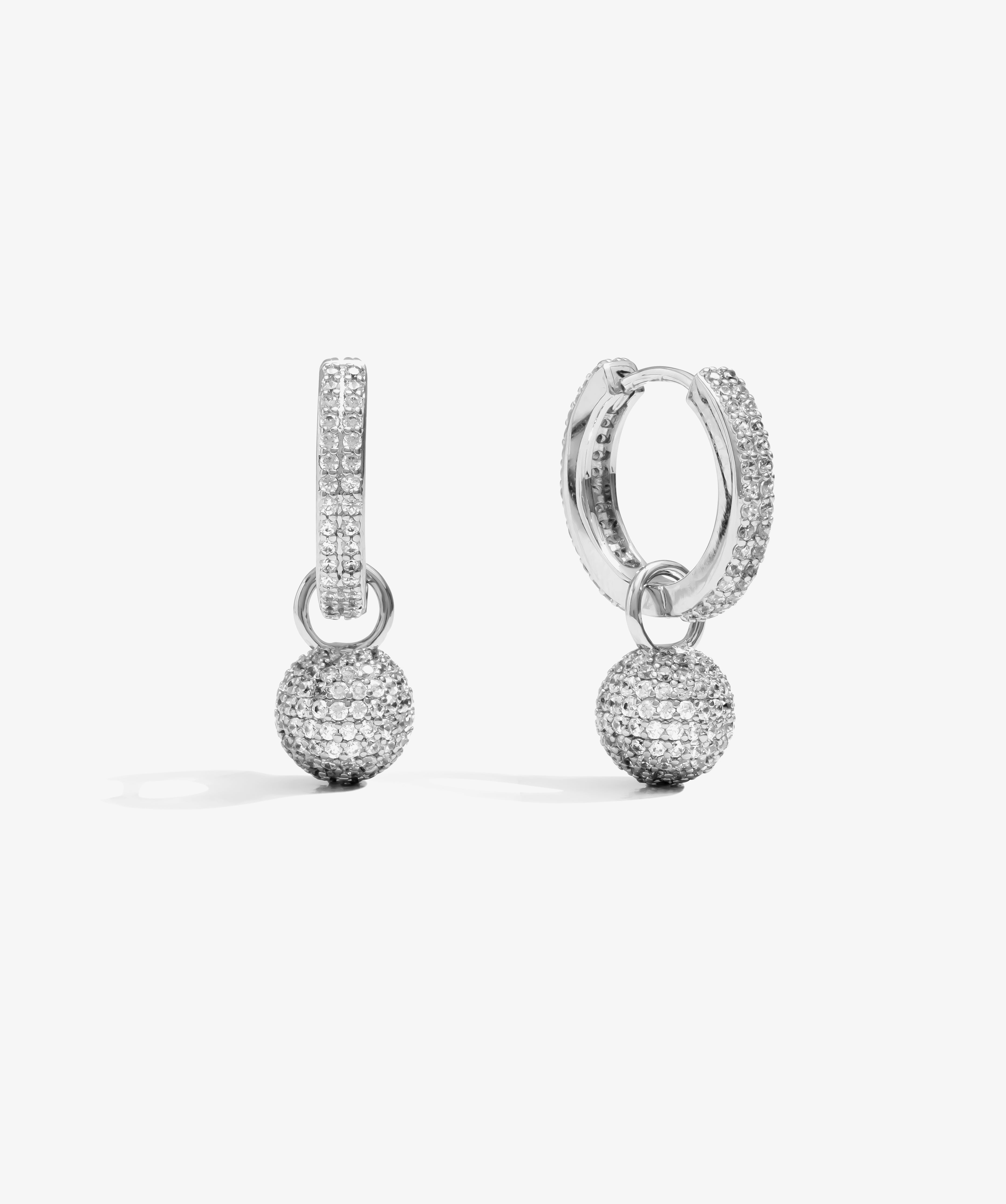 ICED London silver hoop earrings with pavé crystals and dangling crystal ball charms.