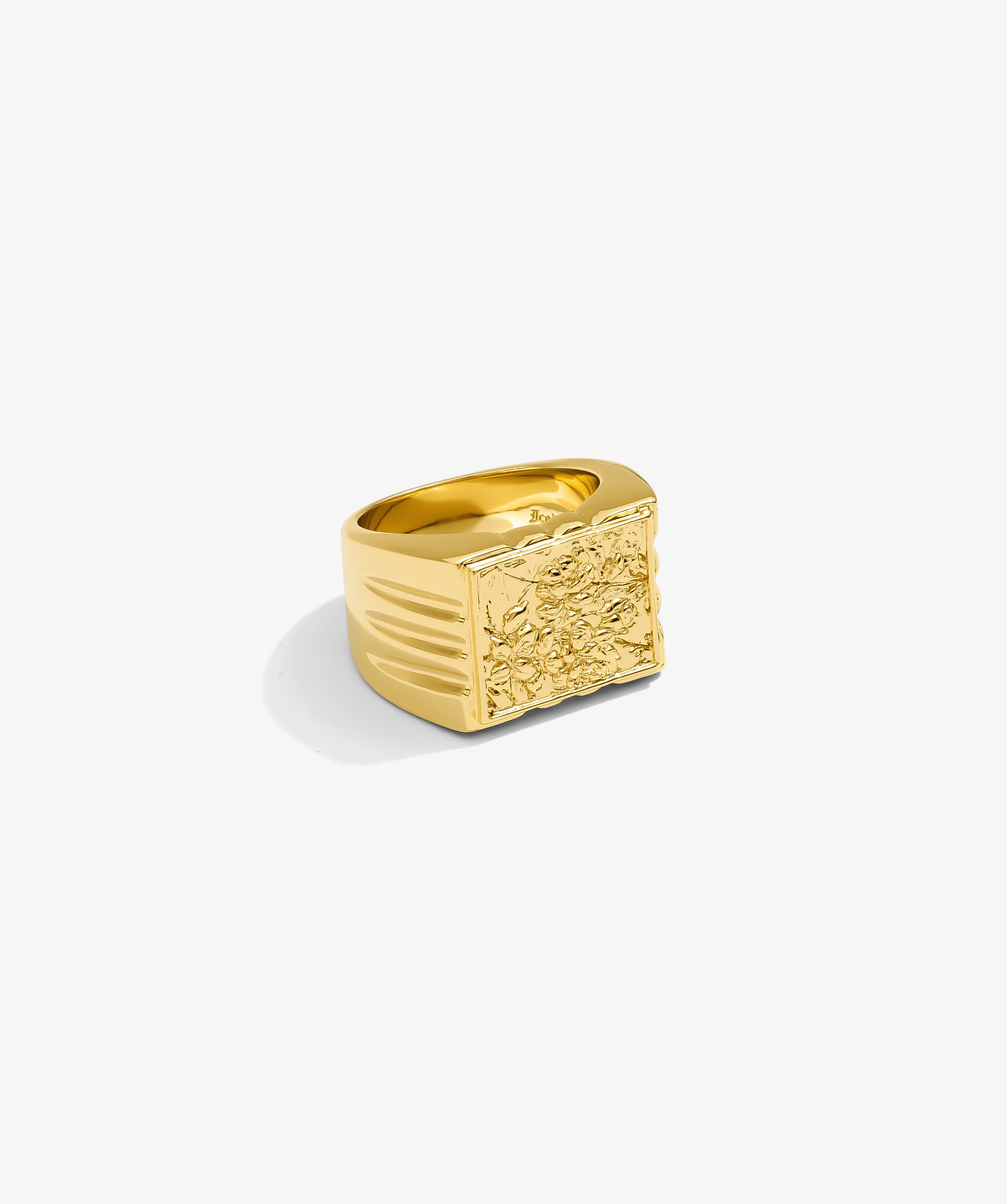 ICED London gold signet ring with an engraved floral panel, bold rectangular face, and ridged sides.