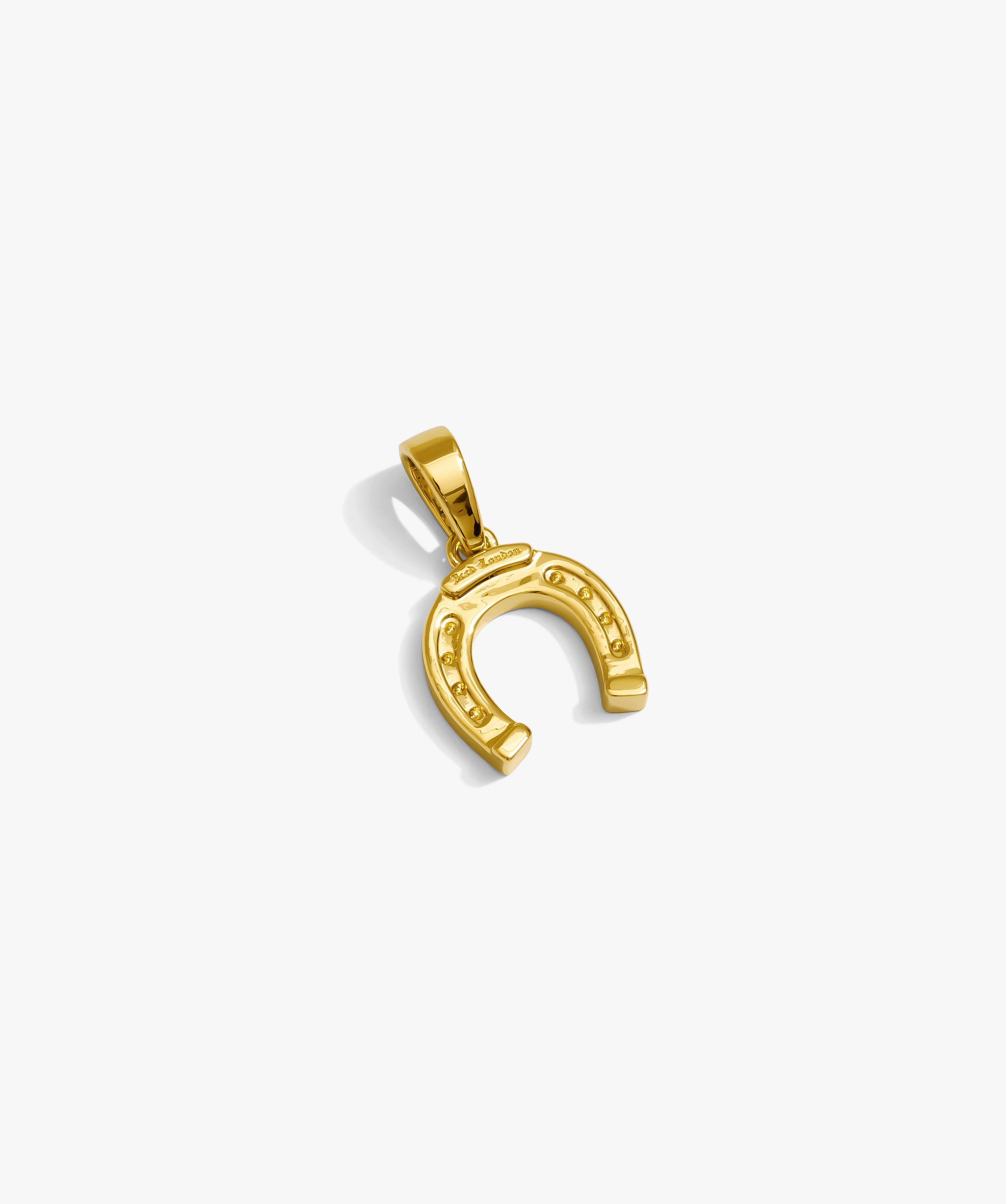 ICED London gold horseshoe pendant, polished yellow-gold charm with small stud details.