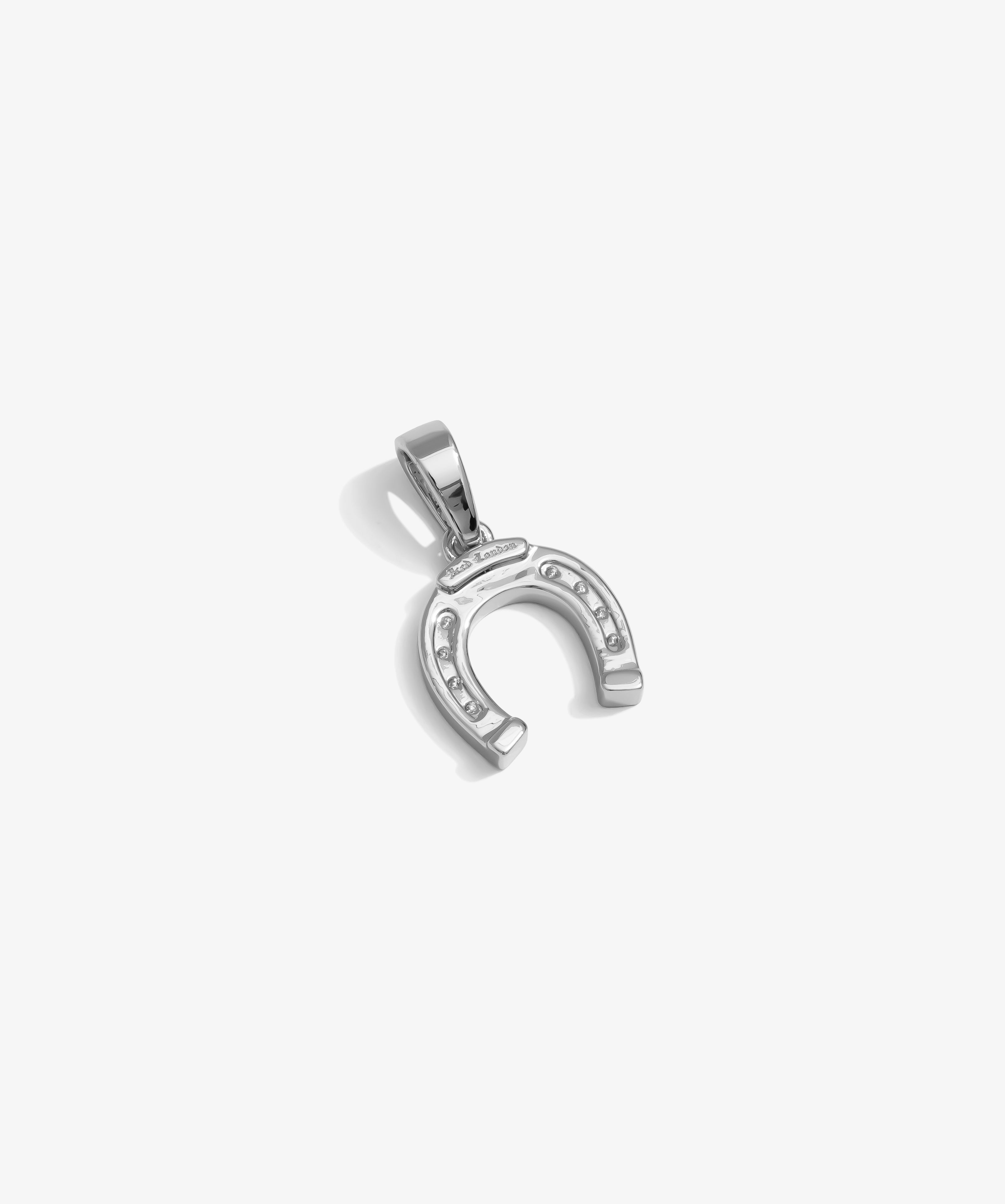 ICED London silver horseshoe pendant with embedded stones, round bail, on white background.