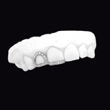 ICED London dental model showing upper teeth with a diamond-studded crown/restoration on the front tooth.